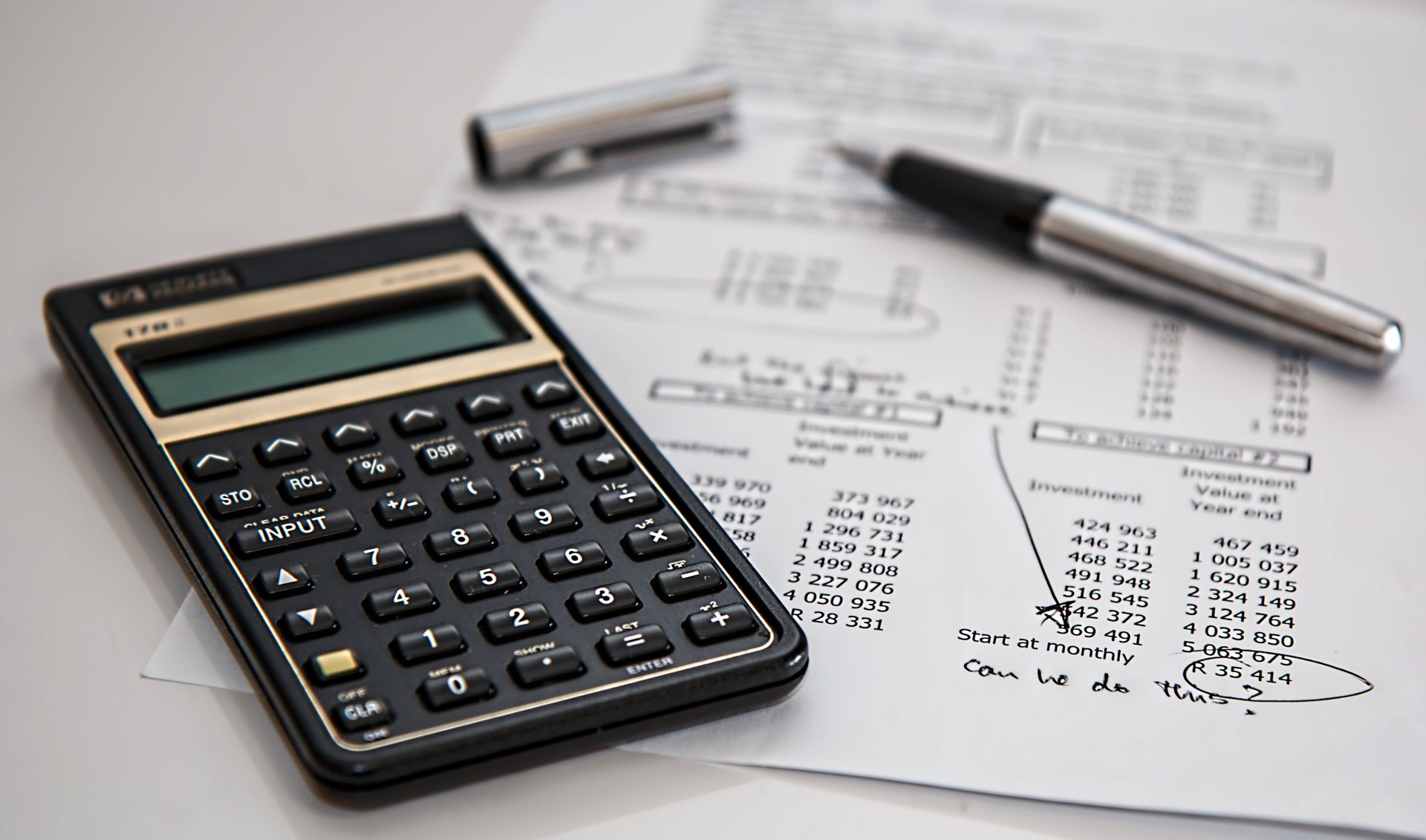 Close-up of financial documents with a calculator and pen
