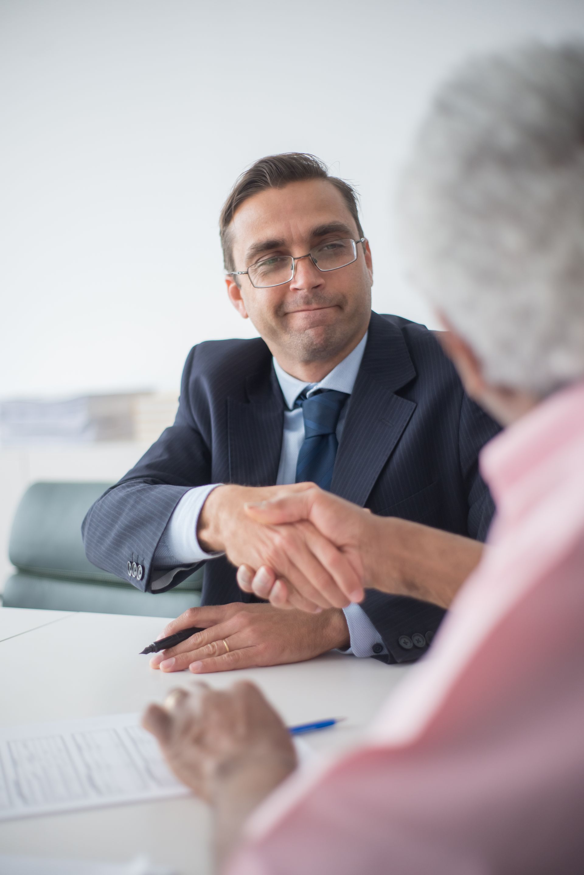 Two businessmen shaking hands in an office setting, symbolizing a successful business deal