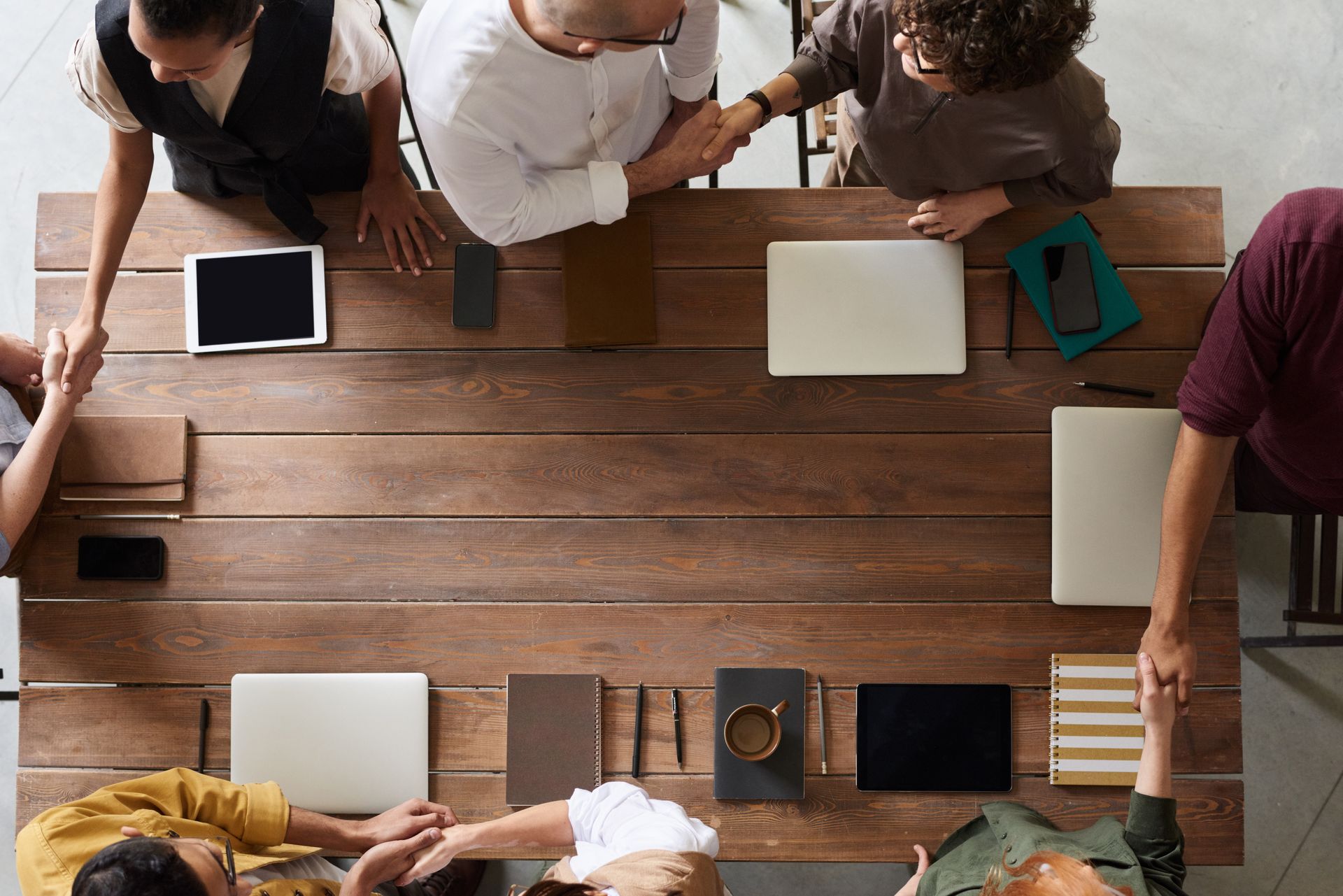 Group of adults having a business meeting, discussing plans around a wooden table