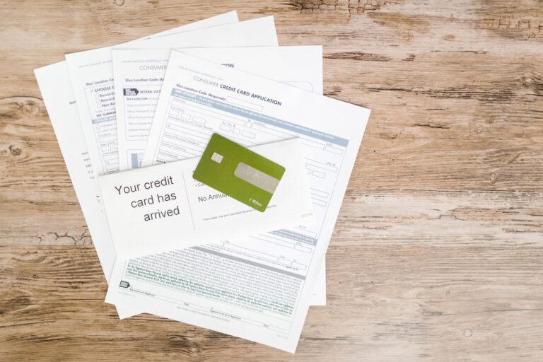 Top view of a credit card and application documents on a wooden surface