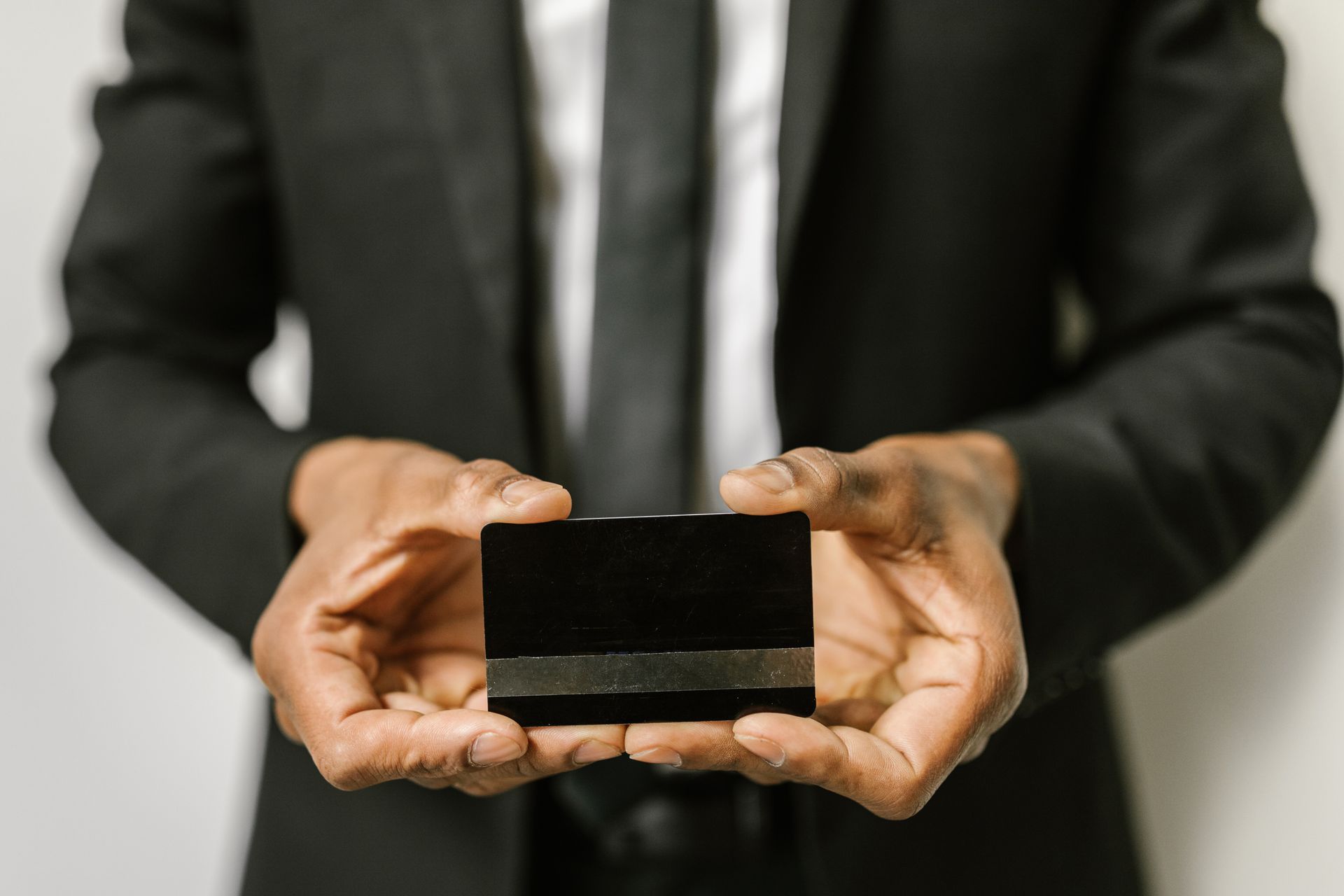 Close-up of a businessman holding a blank credit card with both hands