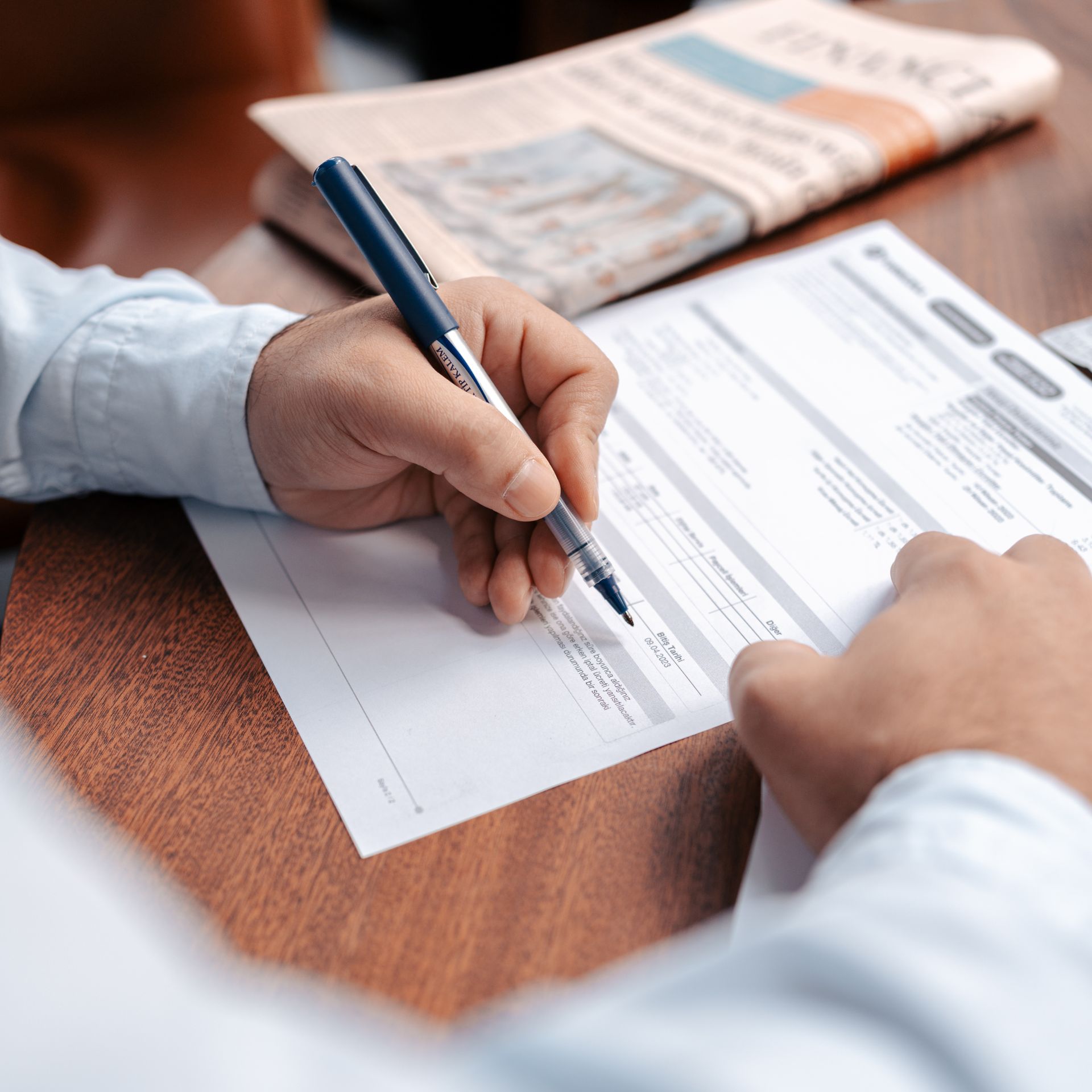 Close-up of hands filling in financial documents