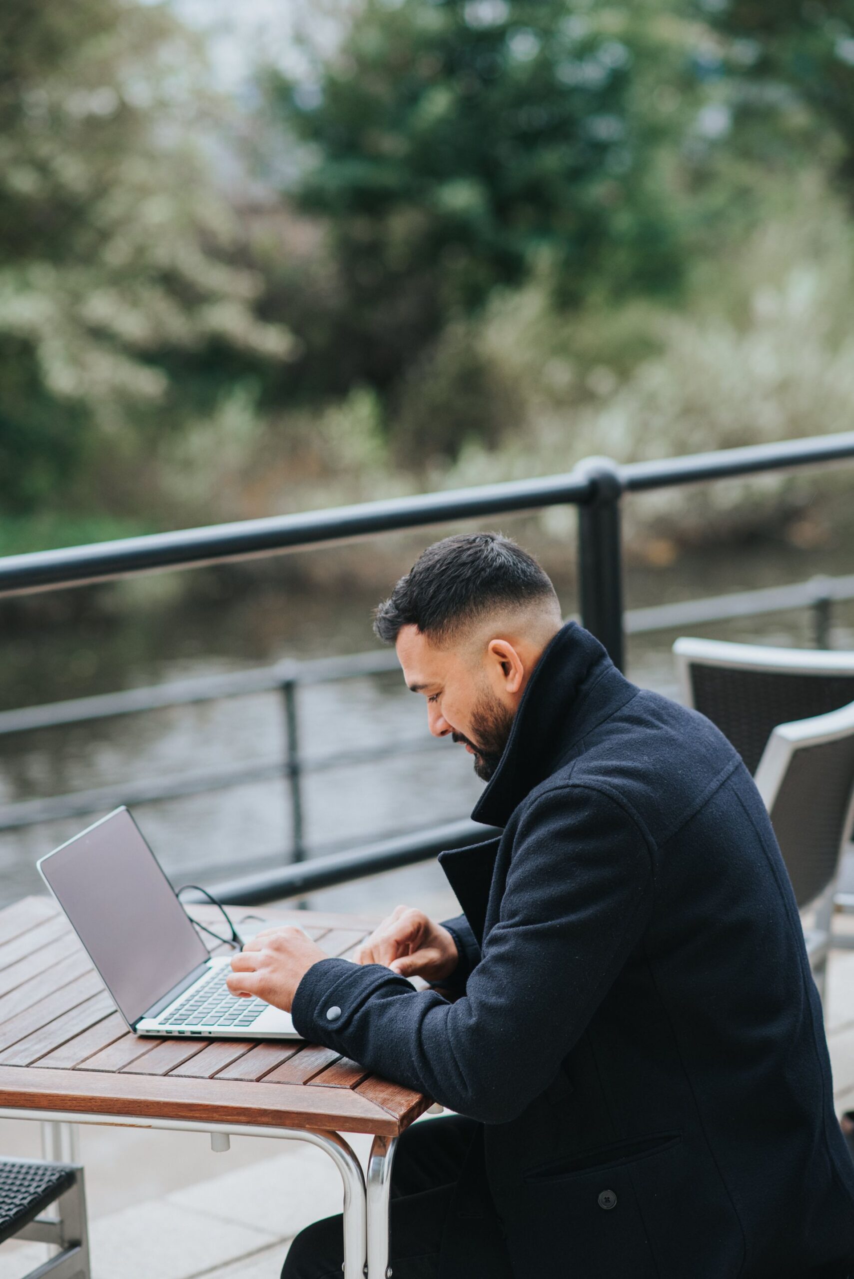 Entrepreneur working on a laptop at an outdoor cafe