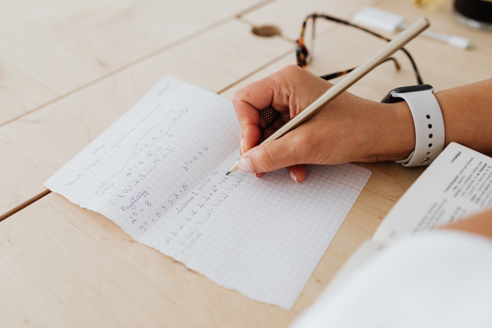 Hand writing financial calculations on paper