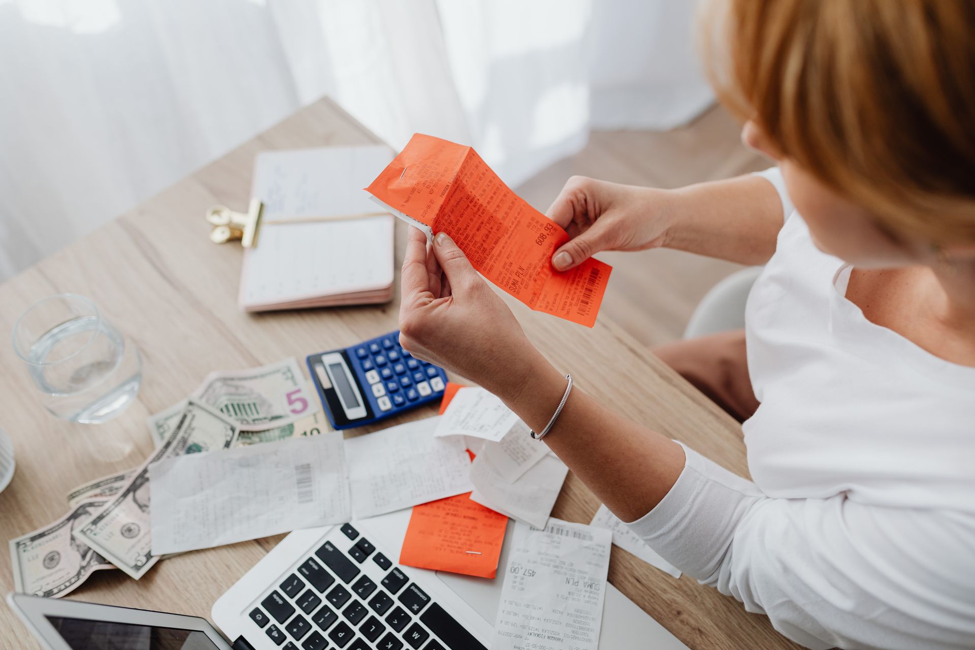 Person organizing bills and expenses at a desk