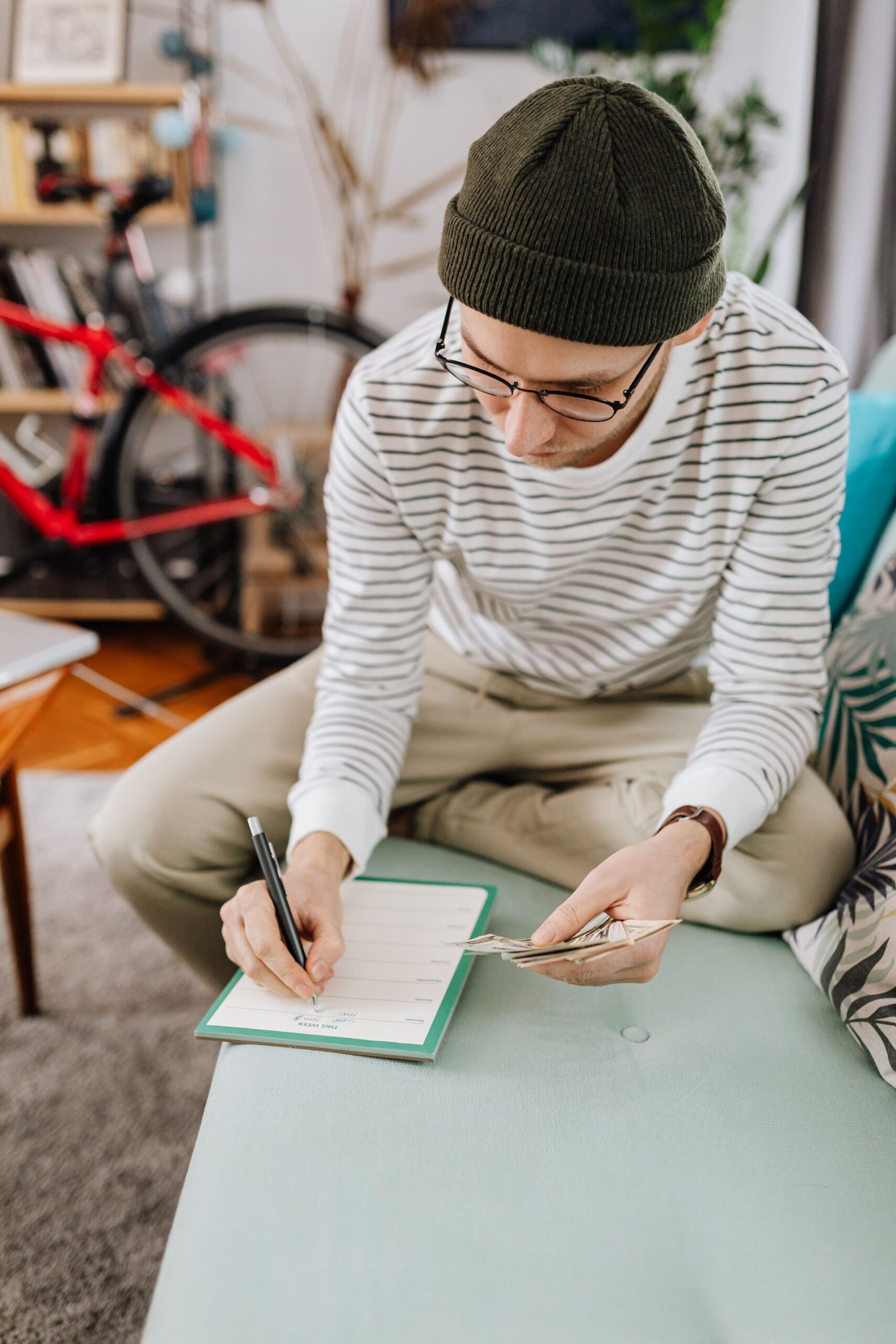 Man writing in a notebook while budgeting money