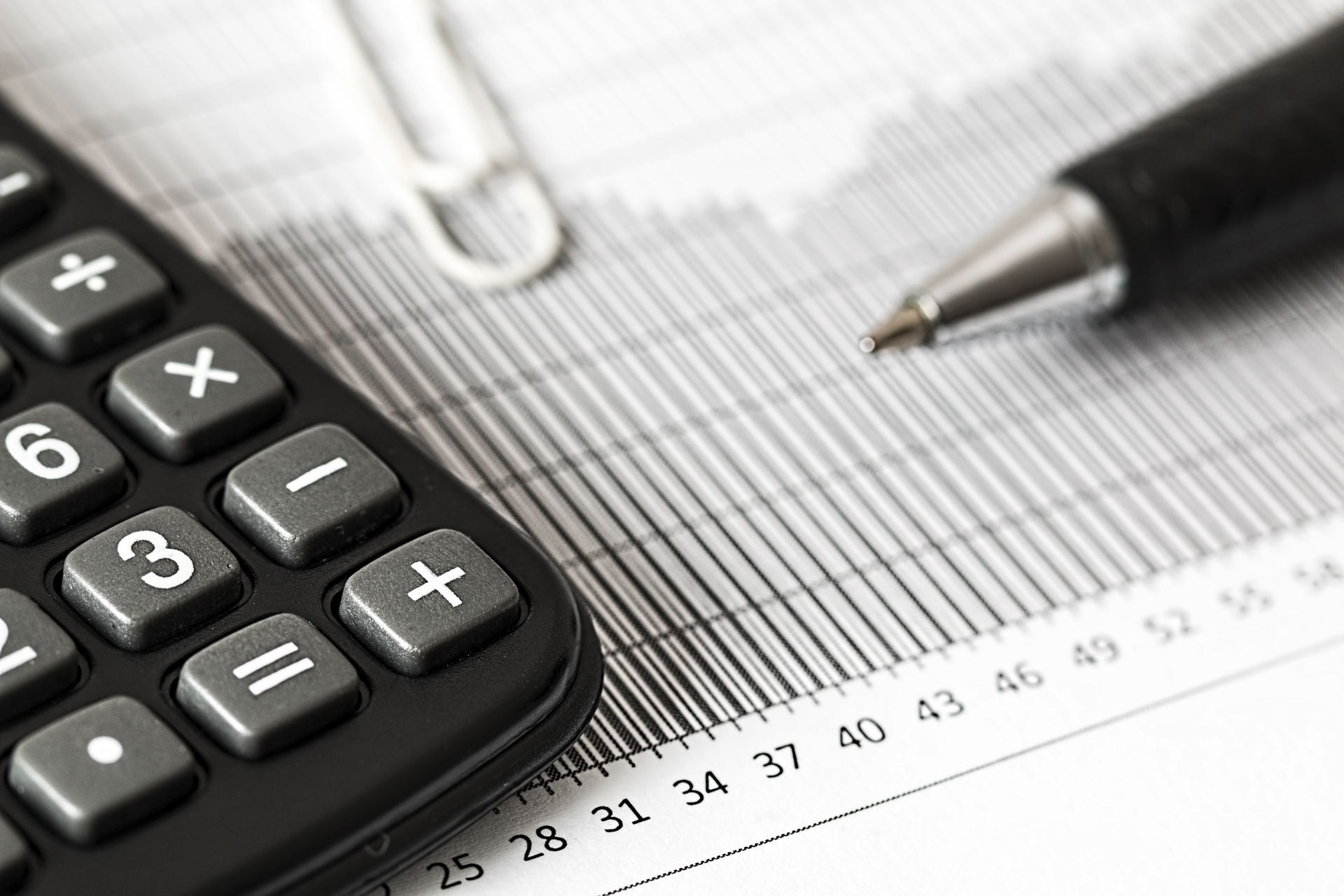 Calculator and pen on a bar graph representing loan accounting