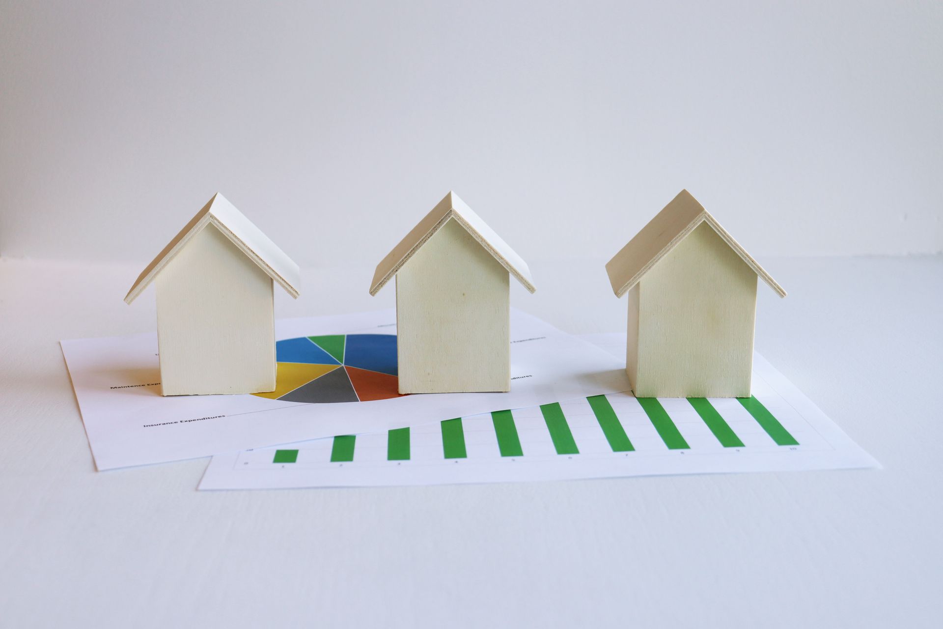 Wooden model houses with printed graphs for mortgage planning