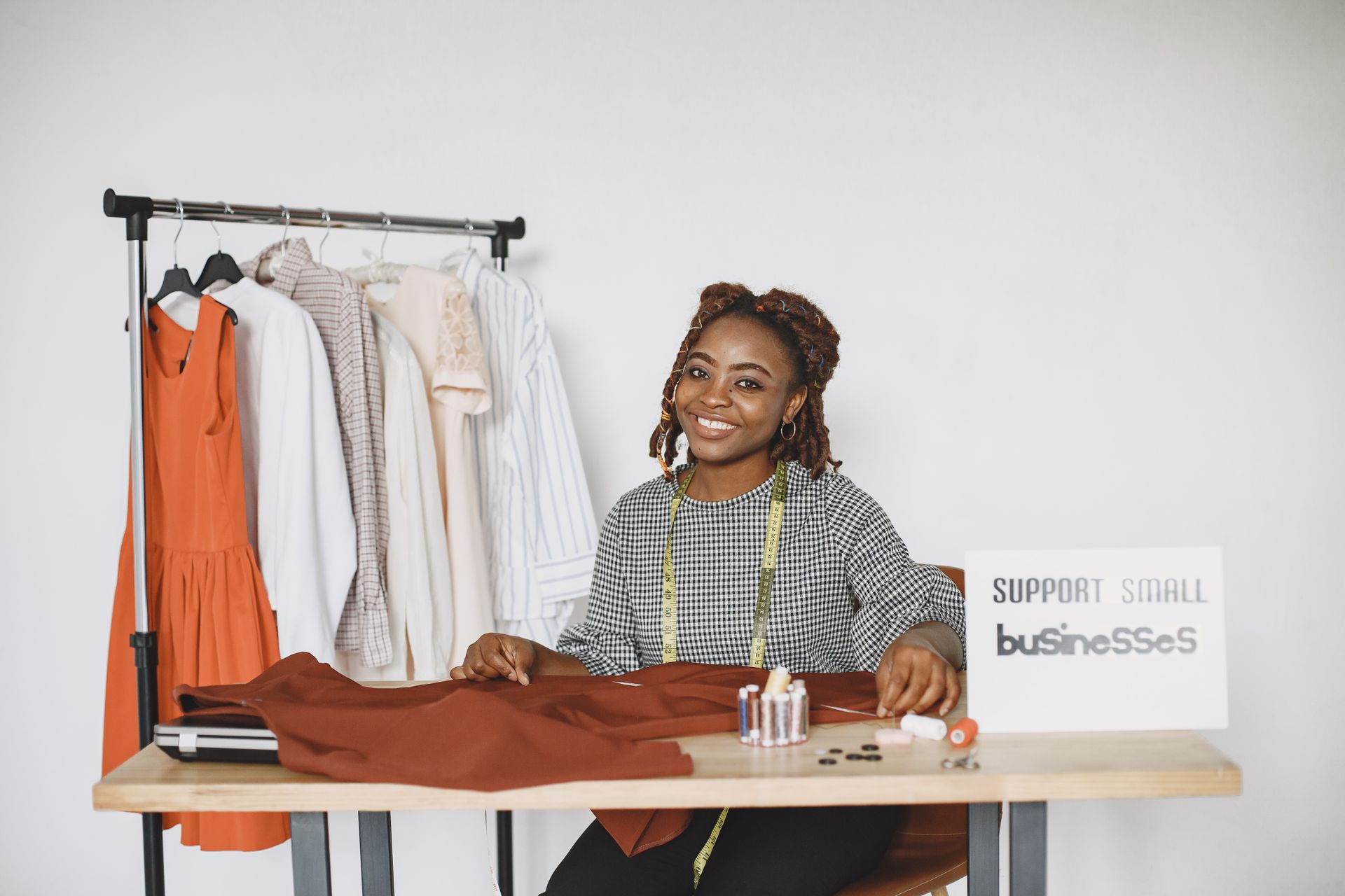 Smiling fashion designer in her studio supporting small business