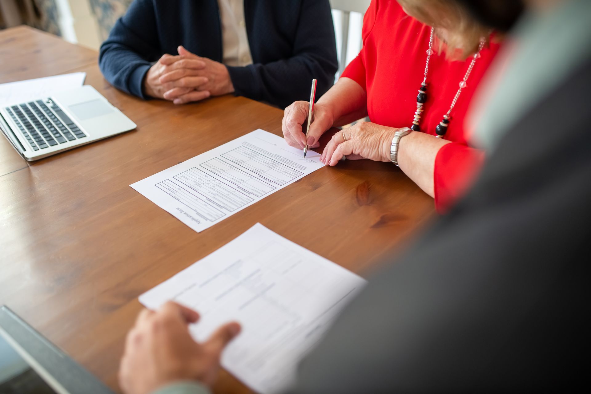 Two adults signing documents at a business meeting