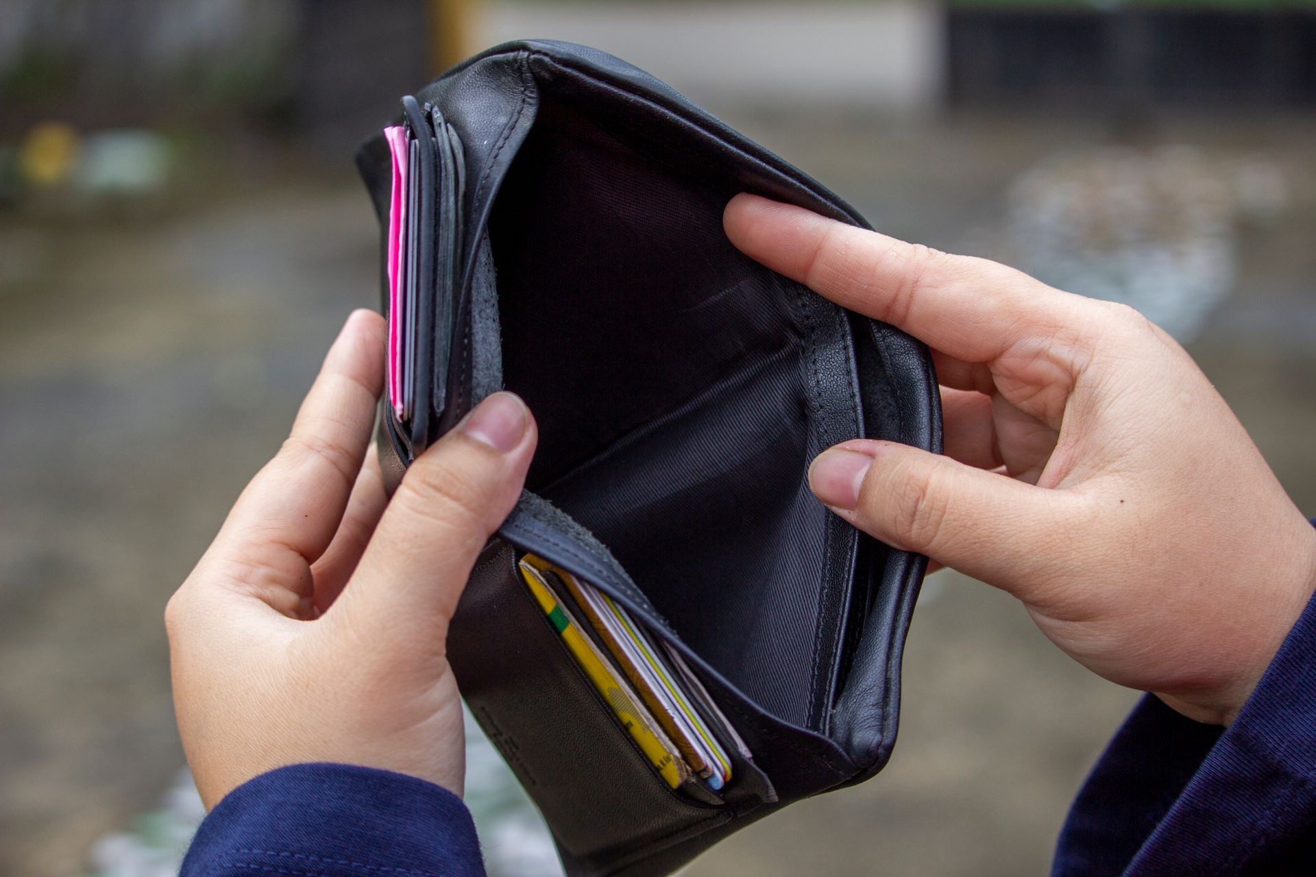 Hands holding an empty wallet suggesting financial difficulty