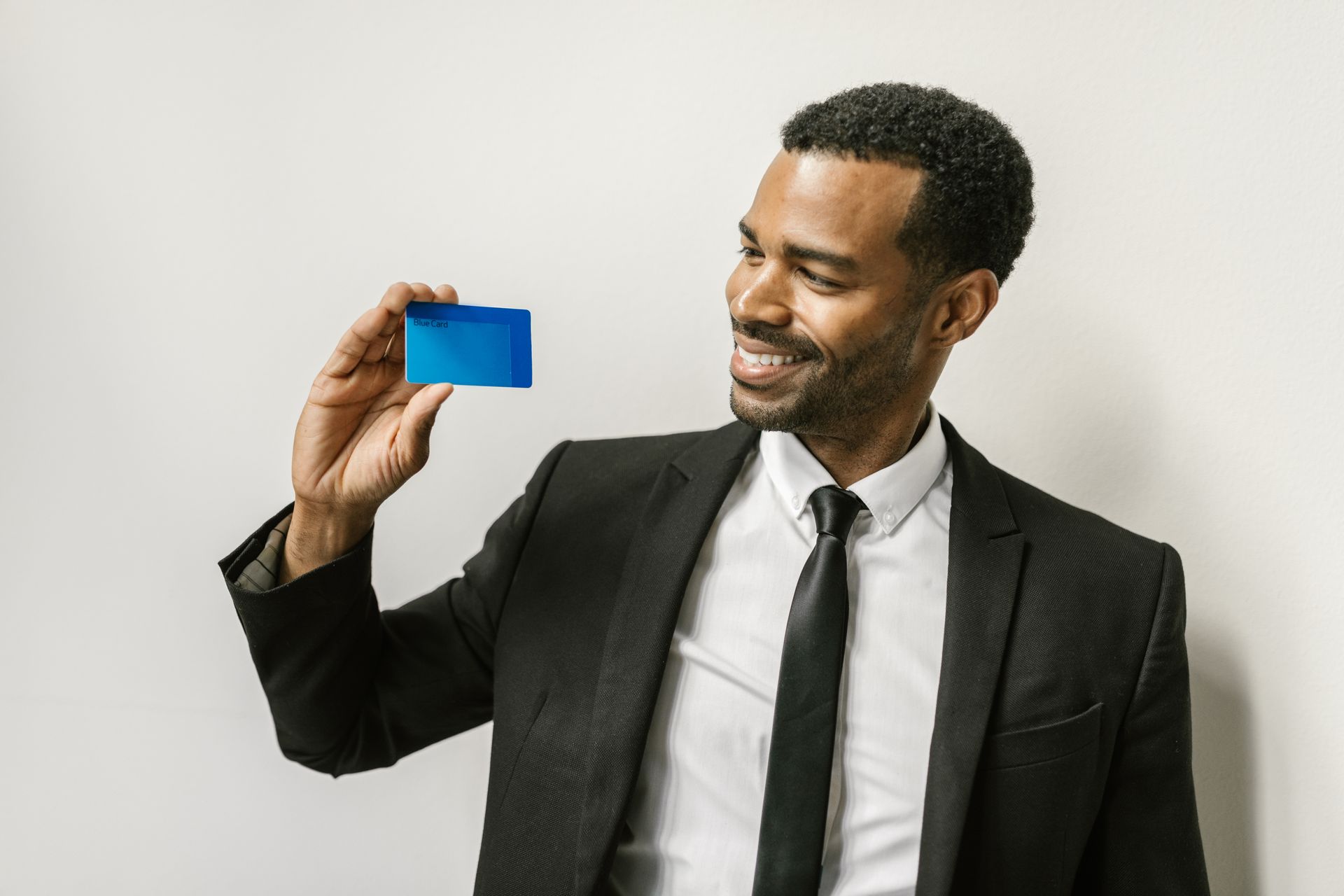 Confident man in a suit holding a credit card
