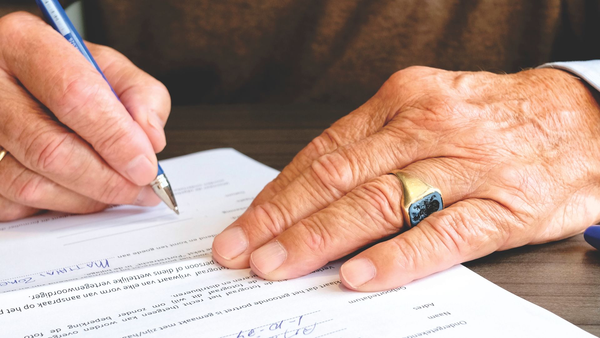 Close-up of a senior adult signing a legal document