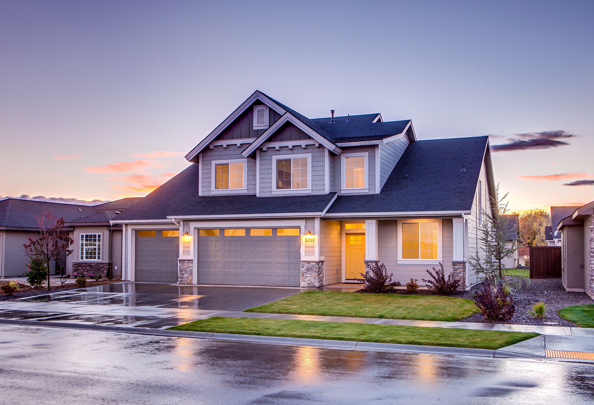 Elegant suburban home with driveway photographed at sunset