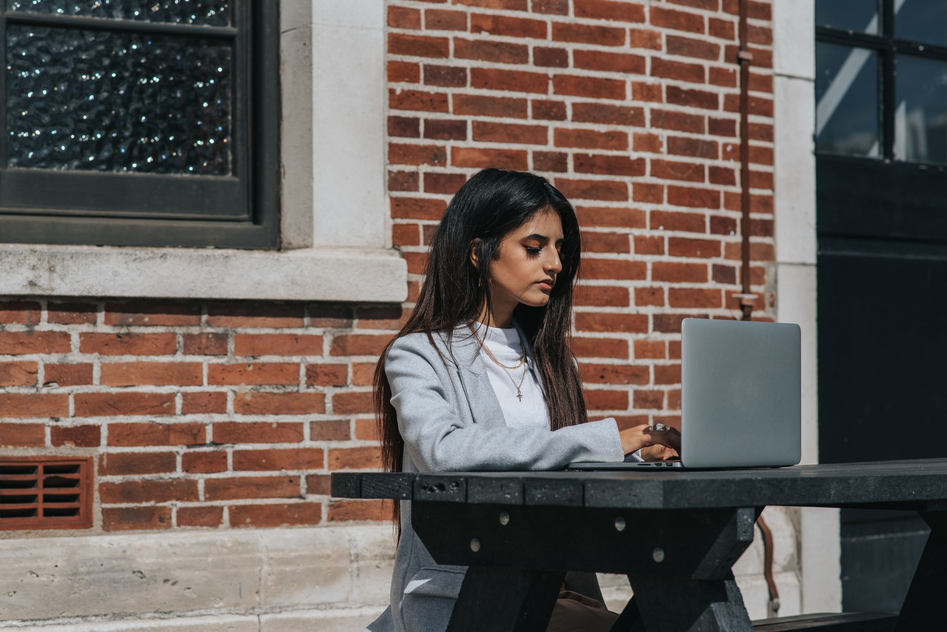 Young entrepreneur working on a laptop at an outdoor table