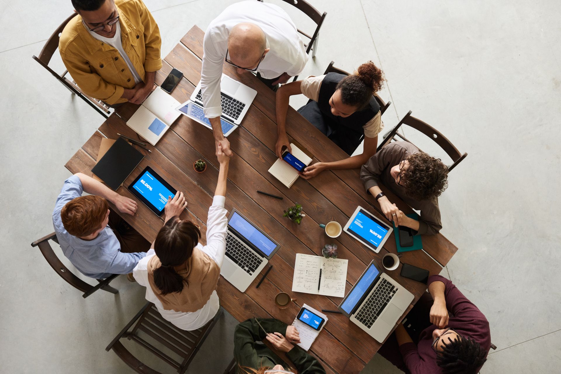 Business partners shaking hands across a table during an office meeting