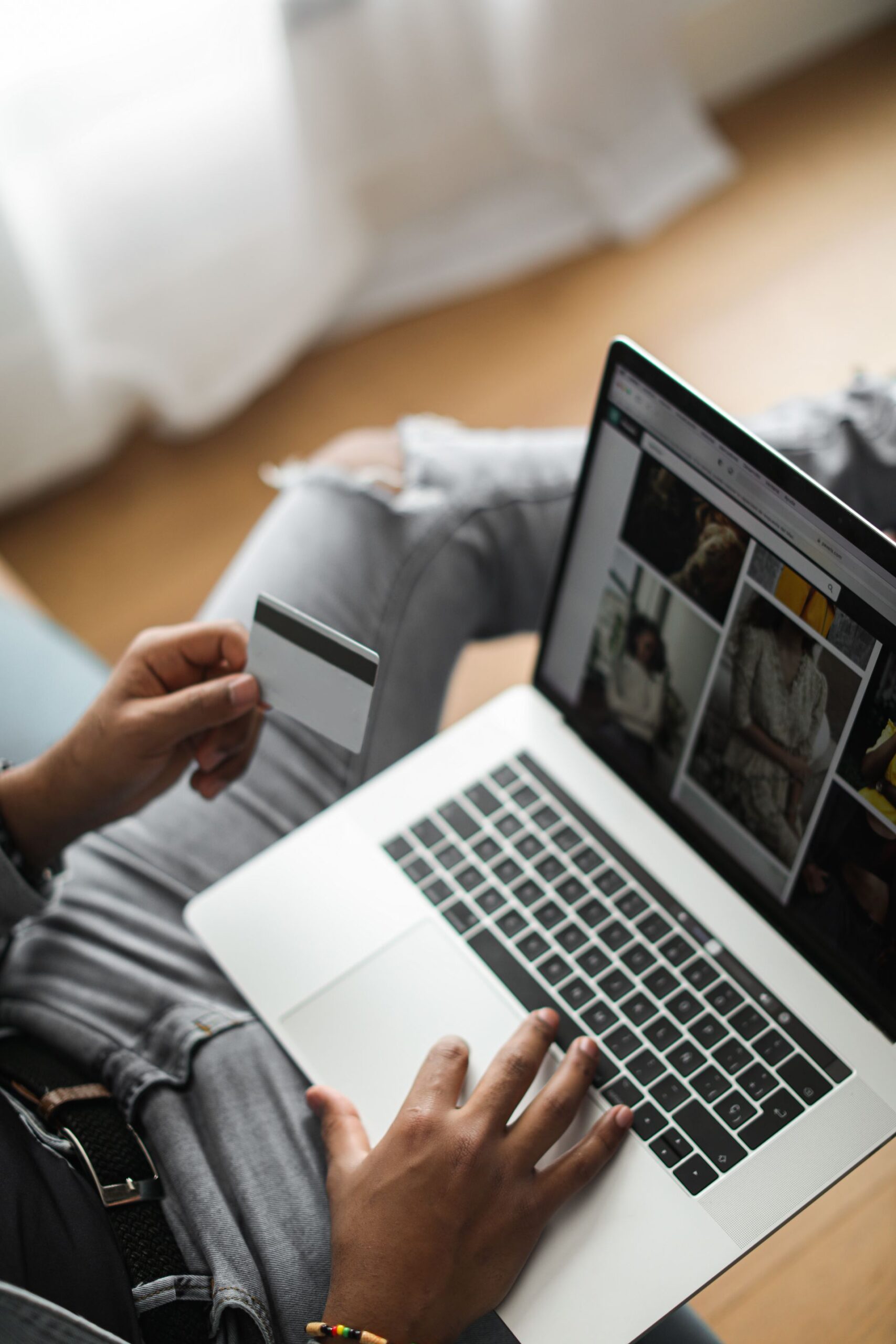 Person reviewing finances on a laptop while holding a credit card
