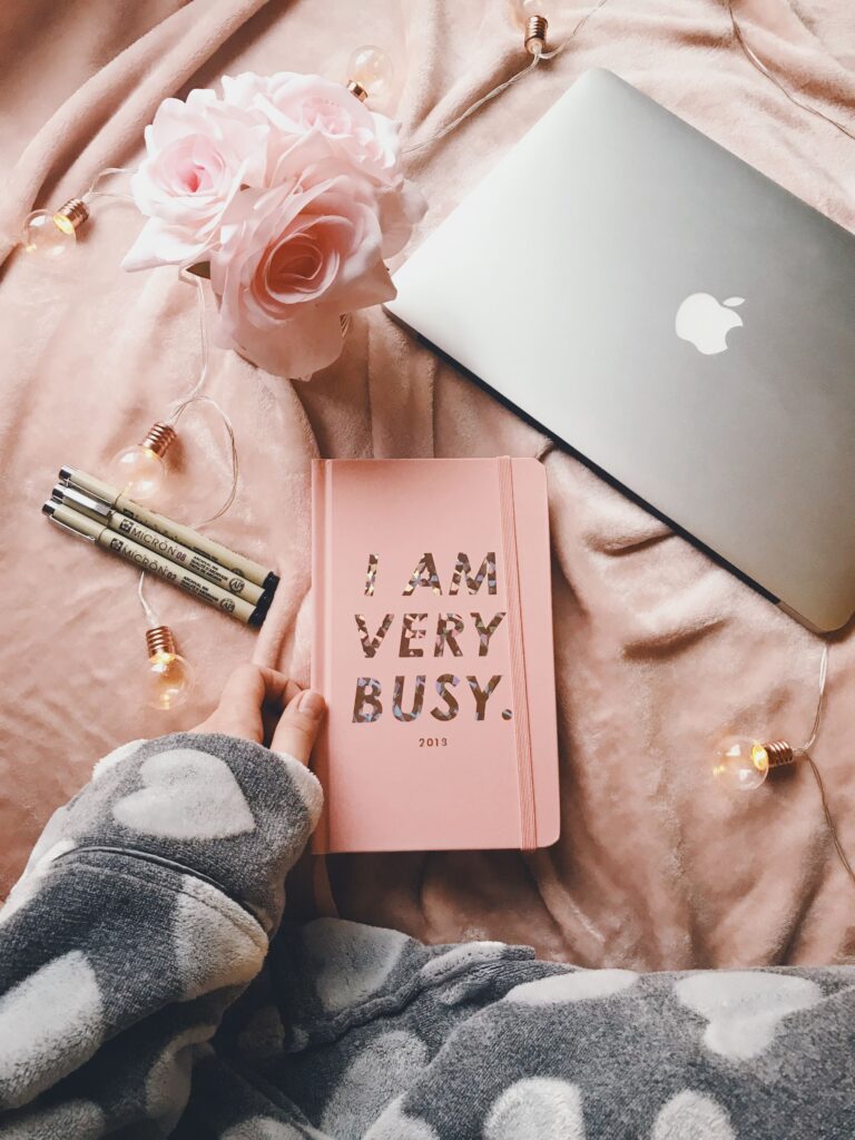 Laptop beside a planner on a desk, flat lay workspace