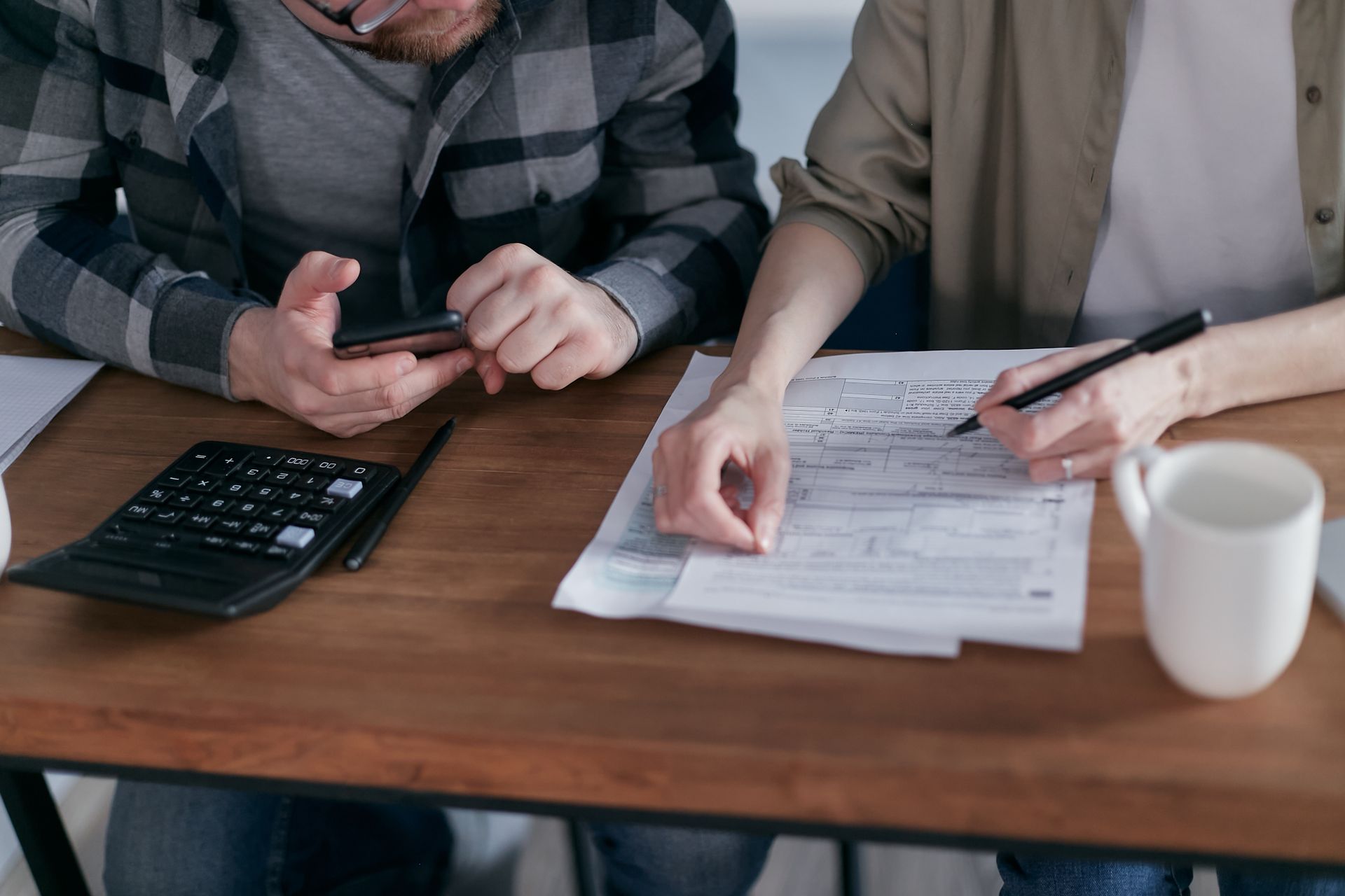 Couple reviewing their finances with calculator and documents at home