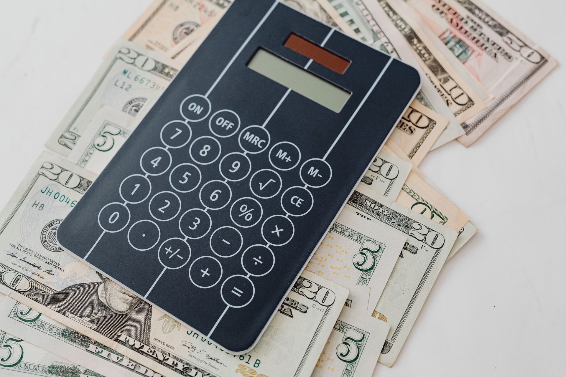 Close-up of a calculator resting on US dollar bills, symbolizing financial planning and budgeting