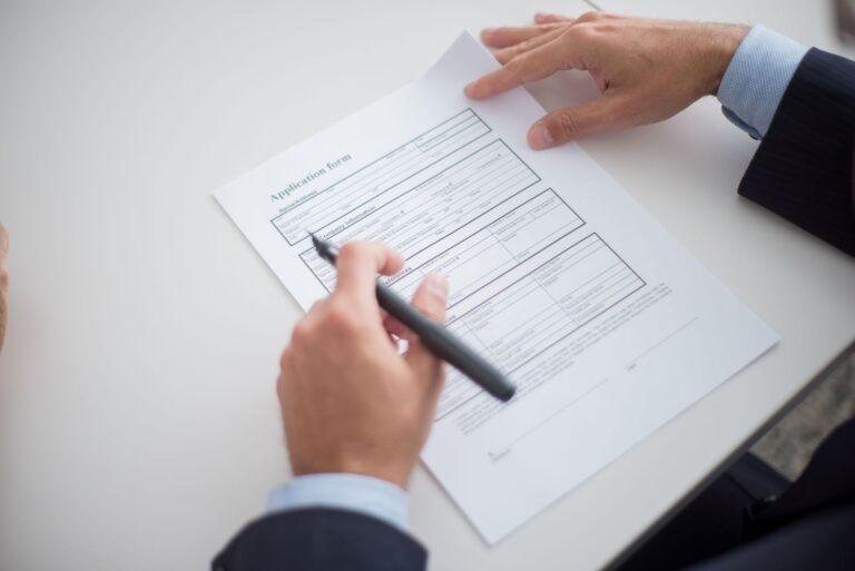 Close-up of a business professional reviewing a loan application form at a desk