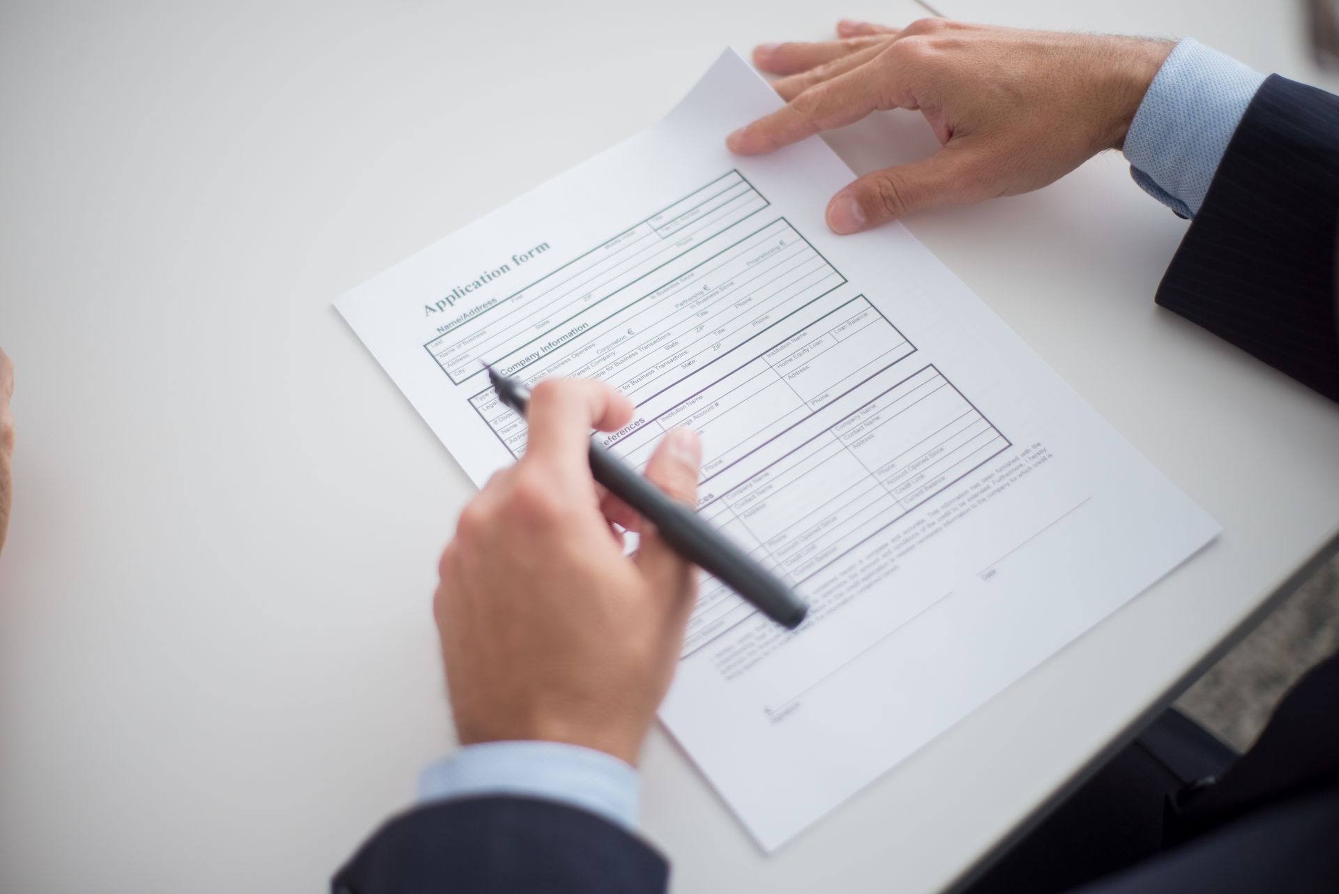 Close-up of a business professional reviewing a loan application form at a desk