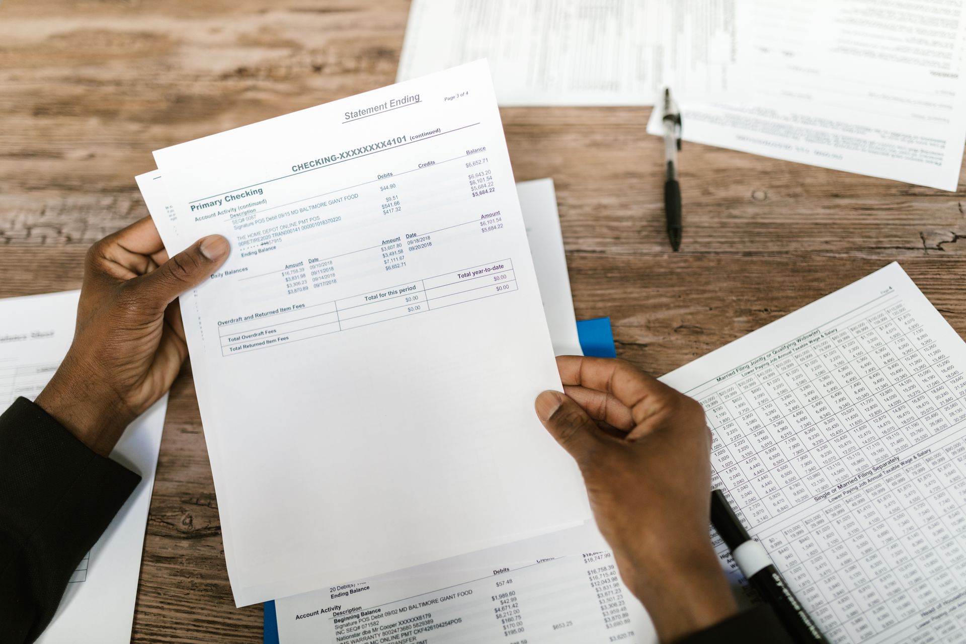 Hands holding financial papers for tax preparation and analysis
